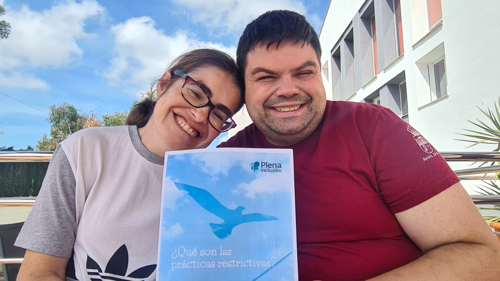 Jesús y Adriana personas que reciben apoyos en la asociación Vale, sosteniendo el manual en lectura facil de Reducción de prácticas restrictivas de Plena Inclusión.