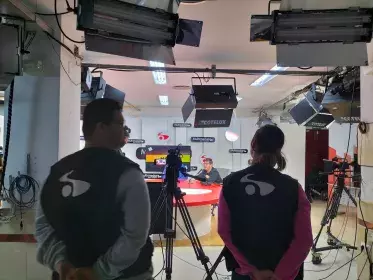 Operario de cámara y de sonido durante la grabacion de una entrevista en un programa