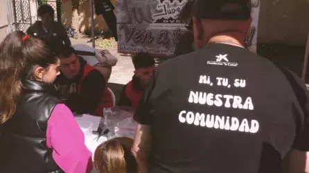 Personas de la comunidad interesados en un stand de una de las asociaciones asistentes en la Feria de Asociaciones generada desde el proyecto "MI,Tu, Su, Nuestra Comunidad"